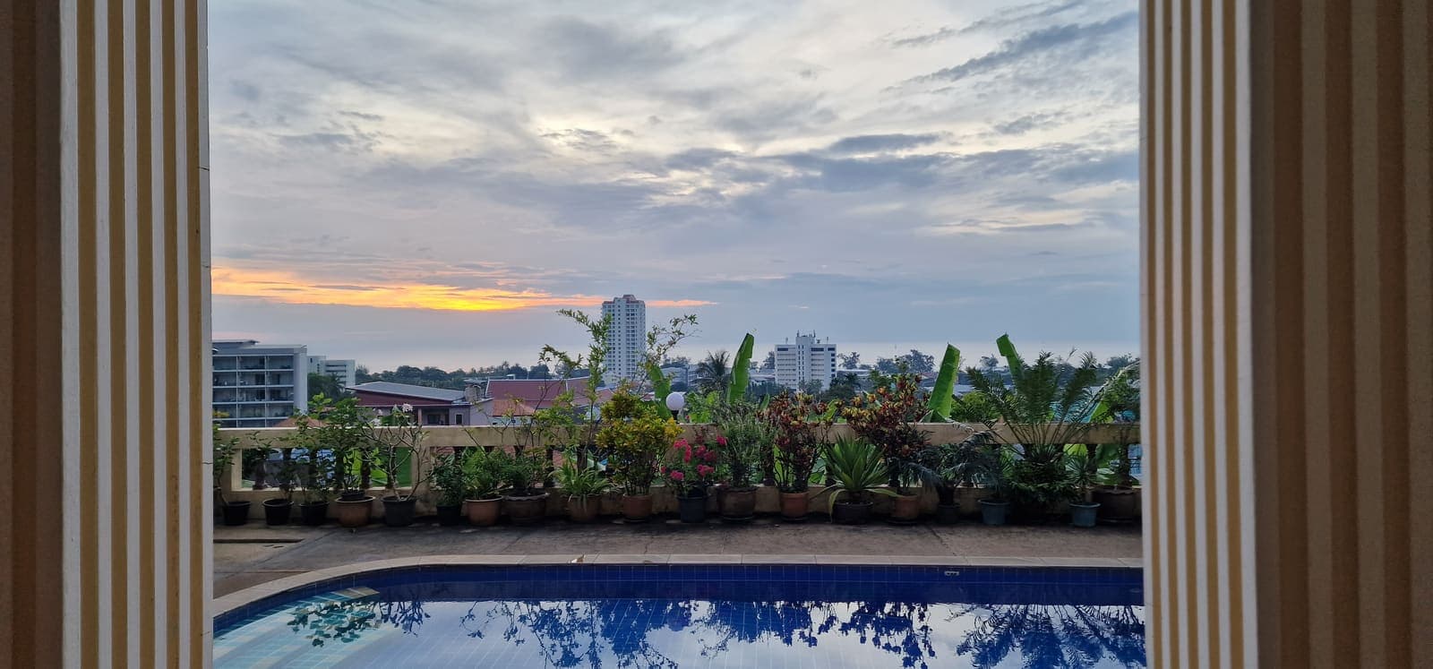 Sunset seen through the terrace columns over the pool