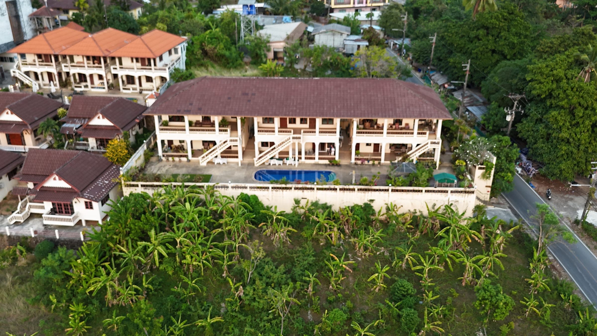 Aerial view of the Karon Hills building, pool and surrounding tropical grounds